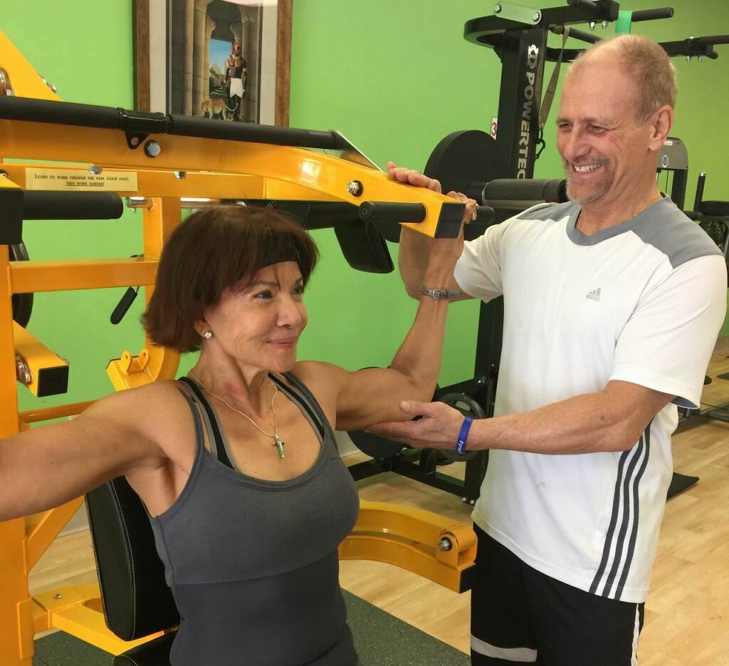 A certified personal trainer guiding a client through a workout in Augusta and Evans.