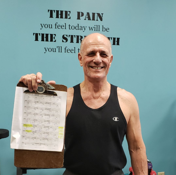 Wally, personal trainer at Body By Wally, presenting a tailored exercise plan to help clients in Augusta reach their fitness goals.