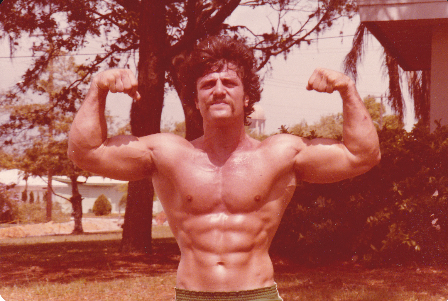 Wally in his youth showing off his impressive muscle definition and bodybuilding prowess with a pose.